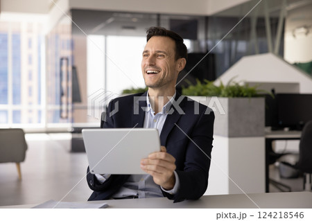 Cheerful carefree businessman in suit enjoying modern digital technology Cheerful carefree businessman in suit enjoying modern digital technology 124218546