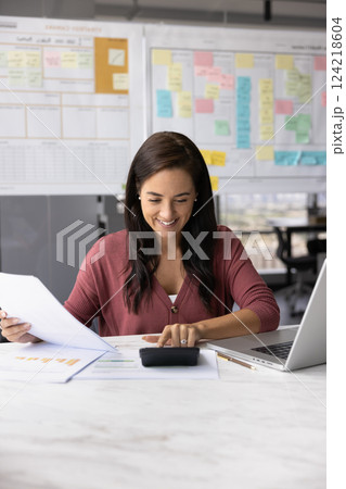 Happy Latin project manager woman counting profit 124218604