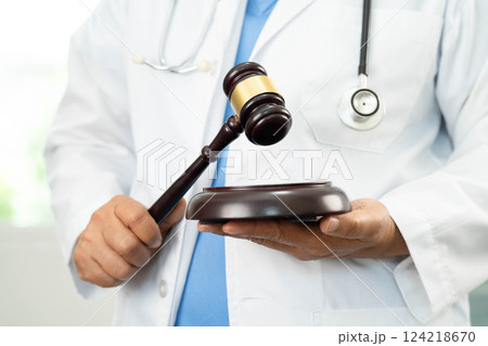 Doctor holding judge gavel, medical law and crime justice. Doctor holding judge gavel, medical law and crime justice. 124218670