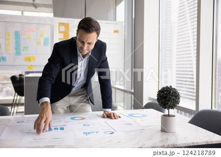 Positive businessman reviewing marketing research results for startup project 124218789
