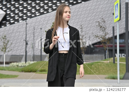 Woman crossing a street on a pedestrian crosswalk in an urban area. 124219277