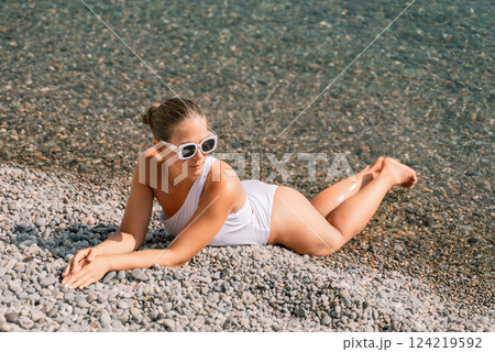 Freelance close up woman hands writing on computer. Well looking middle aged woman typing on laptop keyboard outdoors with beautiful sea view. 124219592