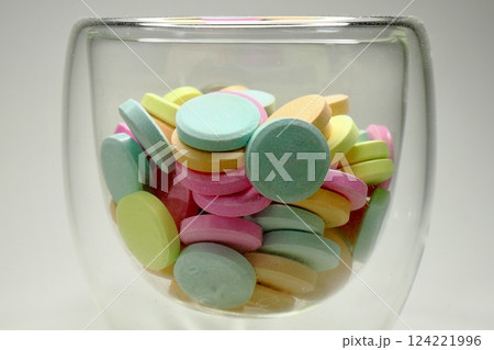 tablets of different colors in a glass bowl 124221996