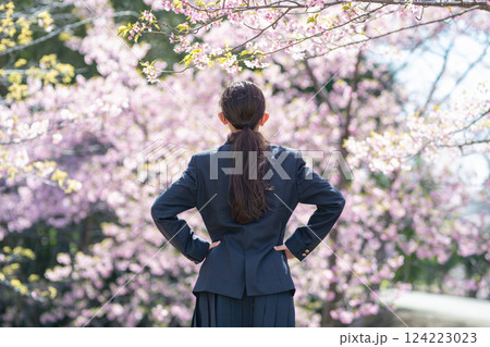 桜の前に立つ学生服を着た女の子 124223023