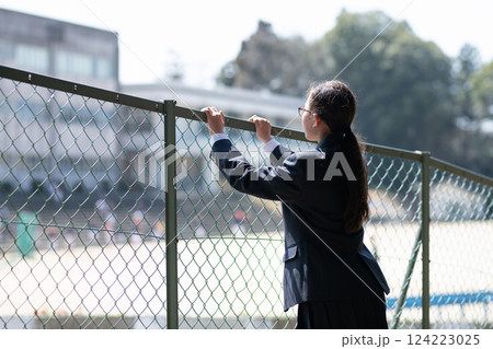 フェンス越しに学校を見る女子生徒 フェンス越しに学校を見る女子生徒 124223025