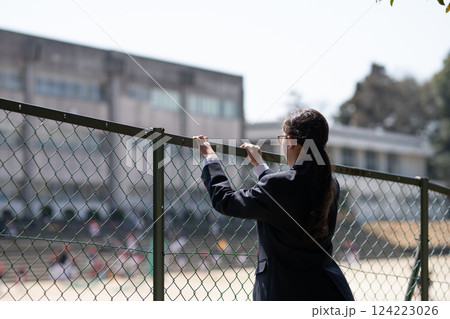 フェンス越しに学校を見る女子生徒 フェンス越しに学校を見る女子生徒 124223026