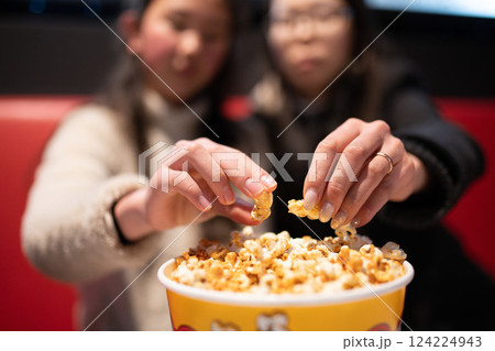 ポップコーンを食べながら映画を見る親子 124224943