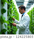 Close-up of a businessman using a tablet in front of an industrial facility, emphasizing digitalization in industry. 124225803