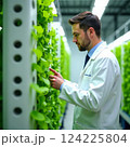 professional holding a tablet against the background of an industrial complex, showcasing digital connectivity. 124225804