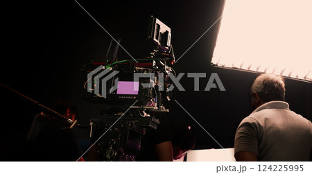 Film or video production setup with high end professional cinema cameras lighting camera rig and crew members working on set. Behind the scenes or BTS video shoot in a studio for cinematic visuals. Film or video production setup with high end professional cinema cameras lighting camera rig and crew members working on set. Behind the scenes or BTS video shoot in a studio for cinematic visuals. 124225995