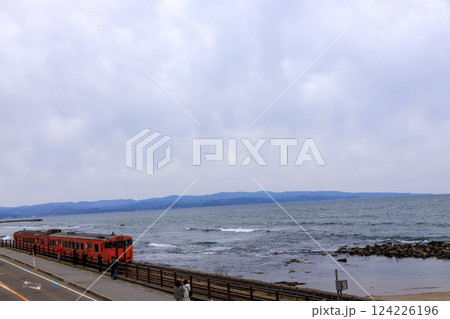 富山県雨晴海岸沿いを走るローカル列車 124226196