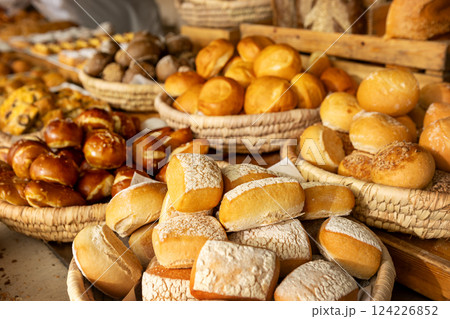 Close-up of freshly baked bread rolls and pretzels in rustic wicker baskets at bakery market. Variety of golden, crusty and whole grain bread selection Close-up of freshly baked bread rolls and pretzels in rustic wicker baskets at bakery market. Variety of golden, crusty and whole grain bread selection 124226852