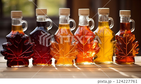 Maple syrup, housed in maple leaf-shaped glass bottles of various sizes, ready to elevate culinary creations with its natural sweetness. AI Generated Maple syrup, housed in maple leaf-shaped glass bottles of various sizes, ready to elevate culinary creations with its natural sweetness. AI Generated 124227761