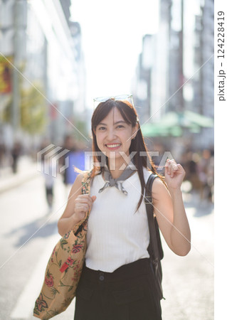 Vibrant Tokyo scene, a modern Asian woman walking with confidence in the midst of urban lights. Vibrant Tokyo scene, a modern Asian woman walking with confidence in the midst of urban lights. 124228419