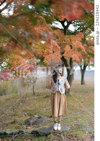 Asian woman in casual dress enjoys Japan's beauty, walking amid vibrant foliage. A cheerful holiday portrait capturing the essence of nature, fashion, and a journey. Asian woman in casual dress enjoys Japan's beauty, walking amid vibrant foliage. A cheerful holiday portrait capturing the essence of nature, fashion, and a journey. 124228442