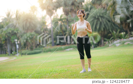 Happy fitness woman achieve goal, finish marathon with hands up, celebrating victory while jogging, triumphing in park Happy fitness woman achieve goal, finish marathon with hands up, celebrating victory while jogging, triumphing in park 124228477