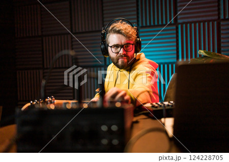 Sound engineer working at mixing panel in the boutique recording studio. 124228705