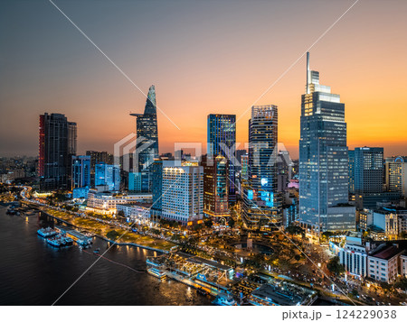 night view of illuminated Ho Chi Minh city skyline and Saigon river, neon street lights of financial downtown district with tall skyscraper towers, Vietnam aerial drone view 124229038
