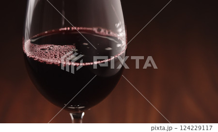 Pour red wine into wineglass closeup with copy space 124229117