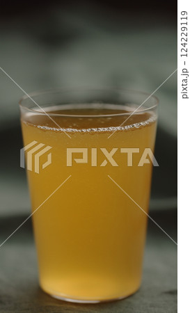 yellow drink in tumbler glas on linen cloth 124229119