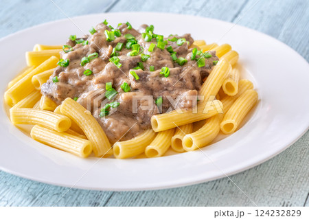 Beef stroganoff with rigatoni pasta, topped with fresh green onion garnish Beef stroganoff with rigatoni pasta, topped with fresh green onion garnish 124232829