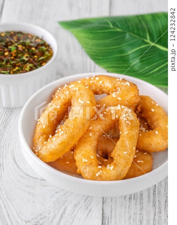 Crispy battered calamari rings with sesame seeds and spicy Asian dipping sauce 124232842