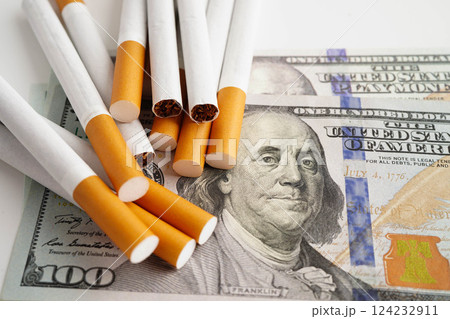 Cigarette on US dollar banknotes, cost, trading, marketing and production, No smoking concept. Cigarette on US dollar banknotes, cost, trading, marketing and production, No smoking concept. 124232911