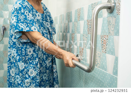 Asian elderly old woman patient use toilet support rail in bathroom, handrail safety grab bar, security in nursing hospital. 124232931