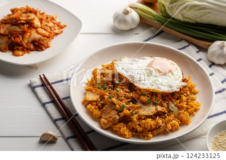 Kimchi fried rice with pork topped with fried egg and sesame seed in white plate.Korean food. 124233125