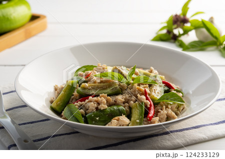 Asian style clean food.Stir fried long green eggplant with ground chicken breast and basil leaves in white plate. Asian style clean food.Stir fried long green eggplant with ground chicken breast and basil leaves in white plate. 124233129