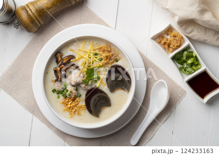 Rice porridge ,Congee with preserved eggs, minced pork, mushroom and ginger in white bowl Rice porridge ,Congee with preserved eggs, minced pork, mushroom and ginger in white bowl 124233163