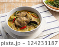 Thai Green Curry Catfish,Sliced catfish with green curry paste in coconut milk soup in white bowl.(kaeng kiew waan ikan keli) 124233187