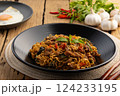 Spicy stir fried instant noodles with sliced beef meat(Strip Loin) and thai basil leaves in black plate 124233195