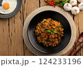 Spicy stir fried instant noodles with sliced beef meat(Strip Loin) and thai basil leaves in black plate.Top view. 124233196