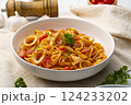 Linguine pasta with squid and cherry tomato in tomato sauce in white plate 124233202