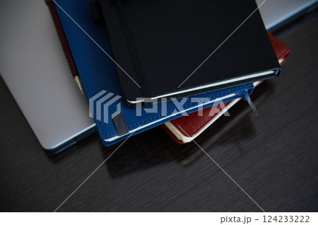 Organized Desk with Stacked Notebooks and Laptop for Productivity 124233222