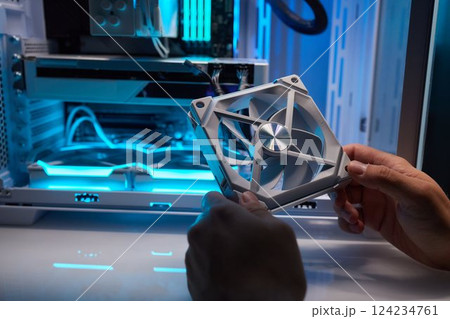 Computer technician installs cooling system of computer. Computer technician installs cooling system of computer. 124234761