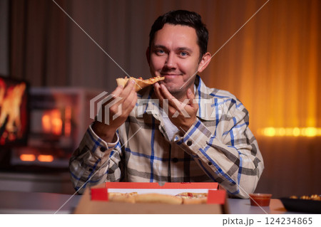 Selective focus on delicious pizza cheerful man is taking from the box. Program developer resting from working, taking a piece of pizza Selective focus on delicious pizza cheerful man is taking from the box. Program developer resting from working, taking a piece of pizza 124234865