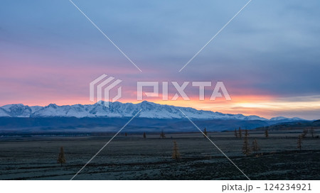 Distant view of high snowy mountains at dusk Distant view of high snowy mountains at dusk 124234921