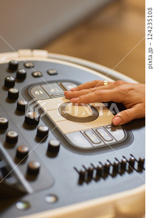 Sonography. Medical ultrasound transducer in doctor's hand, close-up near ultrasound machine in medical clinic 124235108