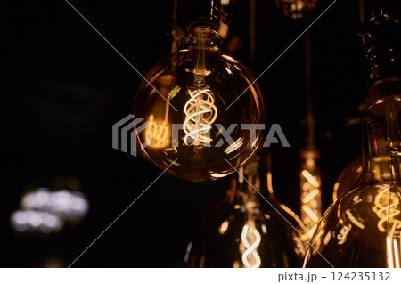 Decorative incandescent bulbs in Edison style on a brick wall background. Decorative incandescent bulbs in Edison style on a brick wall background. 124235132