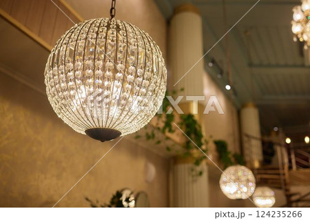 Close-up of a beautiful crystal chandelier Beautiful chandelier. luxury expensive chandelier hanging under ceiling. 124235266