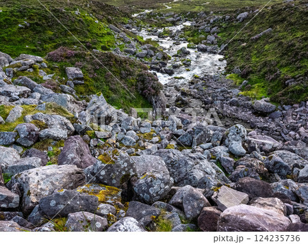 Exploring the serene river landscape of Ireland with rocky terrain and lush greenery. 124235736