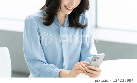 スマートフォンを使う笑顔の女性・ビジネスウーマン スマートフォンを使う笑顔の女性・ビジネスウーマン 124235994
