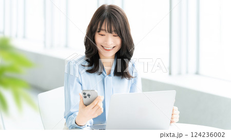スマートフォンを使う笑顔の女性・ビジネスウーマン 124236002