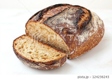 Freshly Baked Artisanal Bread on a White Surface With a Slice Cut Revealing Its Texture and Crust. Generative AI 124236243