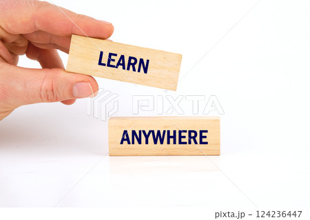 A hand holds a block labeled learn while another block says anywhere, illustrating the flexibility of education in today's world A hand holds a block labeled learn while another block says anywhere, illustrating the flexibility of education in today's world 124236447