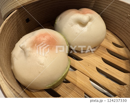 桃まんじゅうが入っている蒸し料理用の竹せいろ 124237330