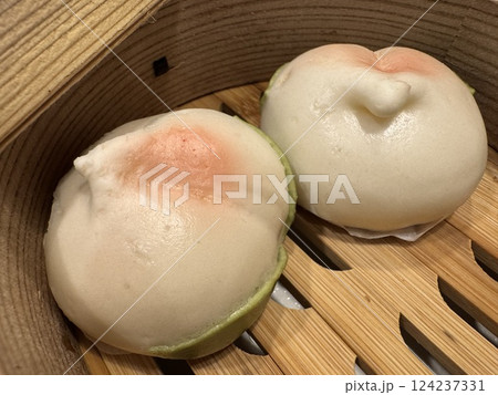 桃まんじゅうが入っている蒸し料理用の竹せいろ 124237331