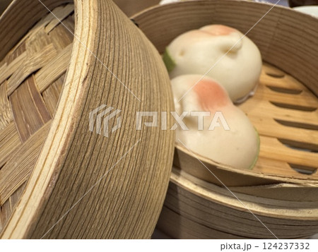 桃まんじゅうが入っている蒸し料理用の竹せいろ 桃まんじゅうが入っている蒸し料理用の竹せいろ 124237332